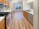 Kitchen featuring stainless steel appliances, wood cabinets and attractive wood-look floors at 2328 Wavetree Nw Ln, Acworth, GA 30101