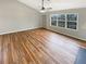 Living room with wood-look flooring, a large window, and a ceiling fan providing natural light at 2328 Wavetree Nw Ln, Acworth, GA 30101