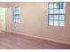 Bright bedroom featuring laminate wood floors and two windows at 5928 Seam St, Lithonia, GA 30058