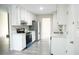 Clean, white kitchen with modern stainless steel appliances and stylish gray wood-look flooring at 5928 Seam St, Lithonia, GA 30058