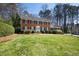 Traditional two-story brick home featuring a lush front lawn and manicured landscaping with a white front door at 1121 Valley Ridge Se Ct, Marietta, GA 30067