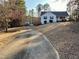 View of a one-story home with long concrete driveway, mature trees, and nice landscaping at 140 Thrasher Rd, Covington, GA 30016