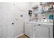 Functional laundry room with a washing machine, dryer, storage shelves, and a clean, white door at 330 Abbey Ct, Canton, GA 30115