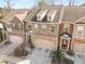 Exterior of a brick townhome featuring a two-car garage, covered entrance, and well-maintained landscaping at 2286 Emerald Sky Dr, Smyrna, GA 30080