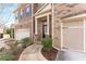 Close up view of a brick townhome exterior featuring a two-car garage, covered entrance, and walkway at 2286 Emerald Sky Dr, Smyrna, GA 30080