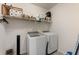 Bright laundry room featuring modern washer and dryer, and convenient shelving for storage at 2286 Emerald Sky Dr, Smyrna, GA 30080