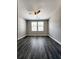 A bright, empty bedroom with gray wood-look flooring, ceiling fan, and two large windows at 2533 Piering Dr, Lithonia, GA 30038