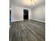 Open-concept living area with gray plank flooring, neutral walls, and a seamless transition to the kitchen at 2533 Piering Dr, Lithonia, GA 30038