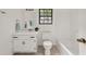Neutral bathroom boasts a white vanity, toilet, tub, and a window for natural light at 277 Hope Dr, Dallas, GA 30157