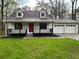 Charming home features a red front door, dormer windows, a black railed porch, and a two-car garage at 277 Hope Dr, Dallas, GA 30157