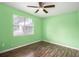 Cozy bedroom with dark wood floors, ceiling fan and a large window at 256 Olde Oaks Ln, Riverdale, GA 30274