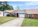 Inviting brick home with a neat lawn, attached garage, and a paved driveway at 256 Olde Oaks Ln, Riverdale, GA 30274