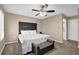Bedroom featuring soft carpet, a ceiling fan, a bed accented by a decorative bench, and natural light through the window at 3608 Stedman Pl, Duluth, GA 30096
