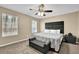 Bright bedroom featuring two windows, soft carpet, a ceiling fan, and a bed accented by a decorative bench at 3608 Stedman Pl, Duluth, GA 30096