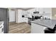 Updated kitchen boasts white cabinets, stainless steel appliances, granite countertops, and hardwood flooring at 3608 Stedman Pl, Duluth, GA 30096