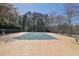 Community pool covered for the off season with surrounding fence and treeline at 3608 Stedman Pl, Duluth, GA 30096