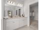 Bright bathroom with a double vanity and a view into the walk-in closet at 4060 Andover Cir, Mcdonough, GA 30252