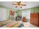 Cozy bedroom with a colorful patterned quilt, desk, and a ceiling fan at 770 Huiet Dr, Mcdonough, GA 30252