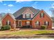 Charming brick home with manicured lawn, classic architectural details, and inviting curb appeal at 770 Huiet Dr, Mcdonough, GA 30252