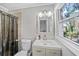 Bright bathroom with a modern vanity, a large window, and a tiled shower with a clear curtain at 2717 Hedgewood Nw Dr, Atlanta, GA 30311