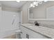 Bathroom with granite countertop, white vanity and shower-tub combo at 2828 Webb Bridge Rd, Alpharetta, GA 30009