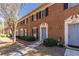 Attractive brick townhomes with blue doors, well-kept shrubs, and sidewalk at 2828 Webb Bridge Rd, Alpharetta, GA 30009