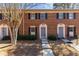 Charming brick townhome with a manicured lawn and blue front doors at 2828 Webb Bridge Rd, Alpharetta, GA 30009