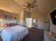 Inviting bedroom with a vaulted ceiling, bed with decorative pillows, and a vanity with a pink mirror at 949 Nevis Way, Mcdonough, GA 30253