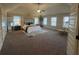 Spacious primary bedroom boasts neutral tones, carpet flooring, and lots of natural light at 949 Nevis Way, Mcdonough, GA 30253