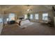 Spacious primary bedroom boasts neutral tones, carpet flooring, and lots of natural light at 949 Nevis Way, Mcdonough, GA 30253