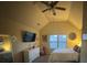 Bright bedroom with vaulted ceiling, ceiling fan, a queen-size bed, art, and natural light at 949 Nevis Way, Mcdonough, GA 30253
