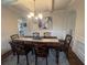 Elegant dining room with decorative chandelier, arched entryway, and wainscoting at 949 Nevis Way, Mcdonough, GA 30253