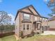 Angle view of a beautiful brick home with a manicured lawn and mulched flowerbeds at 949 Nevis Way, Mcdonough, GA 30253
