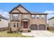 Charming brick two-story home featuring a red front door and well-maintained landscaping at 949 Nevis Way, Mcdonough, GA 30253