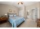 Comfortable bedroom with neutral walls, ceiling fan, and soft blue comforter on bed at 5002 Davenport Pl, Roswell, GA 30075