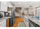 Kitchen with granite countertops, stainless appliances and a view to the wooden staircase at 5002 Davenport Pl, Roswell, GA 30075