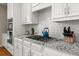 Updated kitchen features granite counters, subway tile backsplash, and stainless cooktop at 5002 Davenport Pl, Roswell, GA 30075