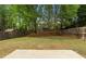 Spacious backyard with grass, trees, and a wooden fence at 3119 Devauden Ct, Duluth, GA 30096