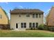 View of the home's back exterior, with a spacious yard and a door leading to a patio at 3119 Devauden Ct, Duluth, GA 30096