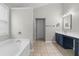Bright bathroom featuring a soaking tub, blue cabinets and neutral tiling at 3119 Devauden Ct, Duluth, GA 30096