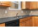 Kitchen with black appliances, light wood cabinets, and a stainless steel sink at 3119 Devauden Ct, Duluth, GA 30096