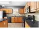 Well-lit kitchen with black appliances and light wood cabinets at 3119 Devauden Ct, Duluth, GA 30096
