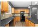 Cozy kitchen featuring light wood cabinets, black appliances, and modern countertops at 3119 Devauden Ct, Duluth, GA 30096