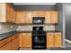 Charming kitchen with black appliances, light wood cabinets, and stone countertops at 3119 Devauden Ct, Duluth, GA 30096