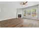 Open-concept living room with a cozy fireplace, ceiling fan, and lots of natural light at 3119 Devauden Ct, Duluth, GA 30096
