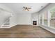 Spacious living room featuring a fireplace, a ceiling fan, and light-filled windows, wood-look floors at 3119 Devauden Ct, Duluth, GA 30096