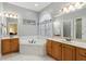 Well-lit bathroom featuring a soaking tub, dual sinks, and modern fixtures at 4741 Covenant Way, Powder Springs, GA 30127