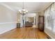 Open dining room with hardwood floors, elegant chandelier, and view of the living area at 4741 Covenant Way, Powder Springs, GA 30127