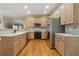 Well-equipped kitchen features stainless steel appliances and light wood cabinets with tile backsplash at 4741 Covenant Way, Powder Springs, GA 30127