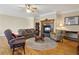 Cozy living room features a fireplace and hardwood floors, with plush seating and a ceiling fan at 4741 Covenant Way, Powder Springs, GA 30127